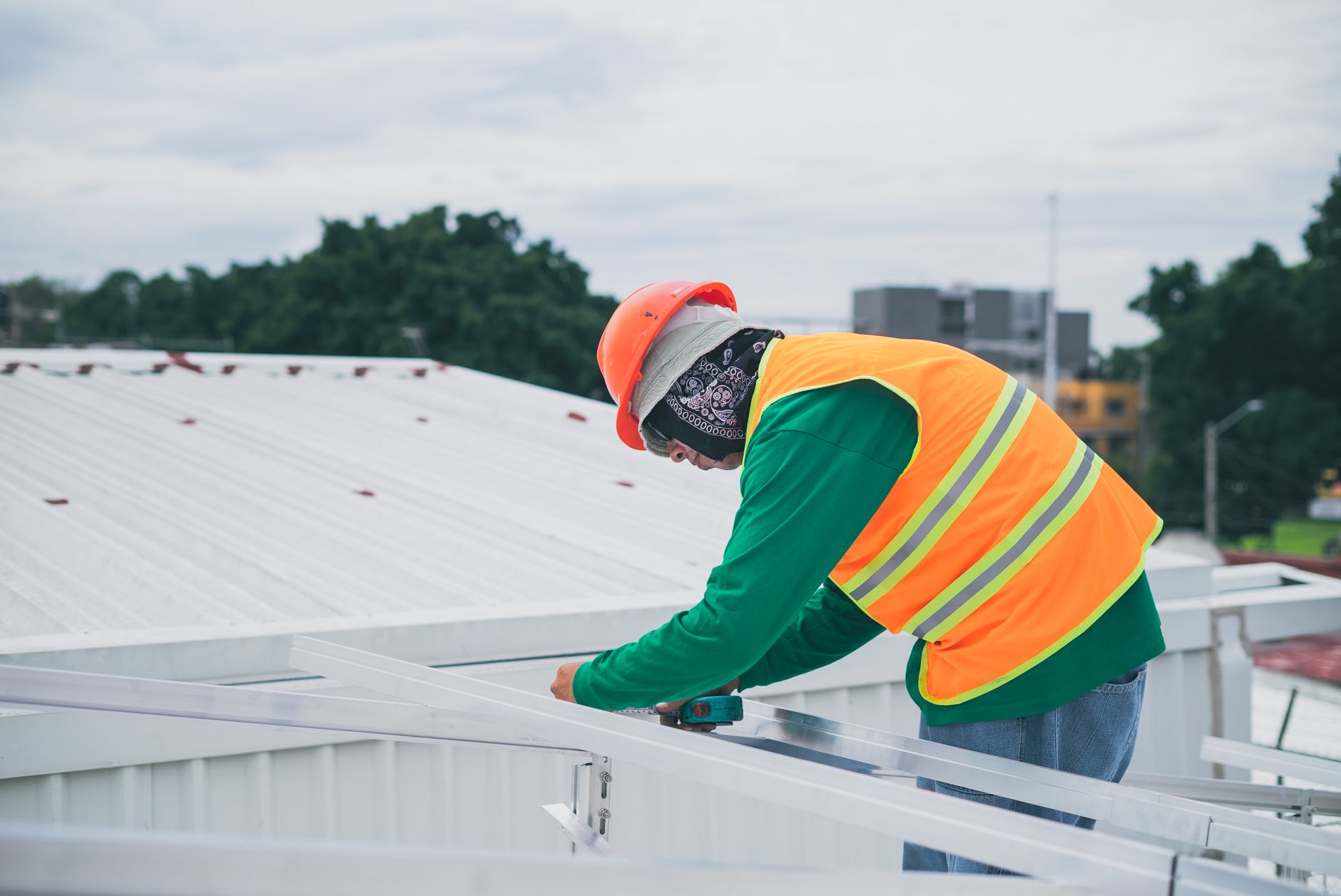 Skilled roofer inspecting a low-slope roof with TPO membrane on a Spring Valley home, ensuring quality and durability.