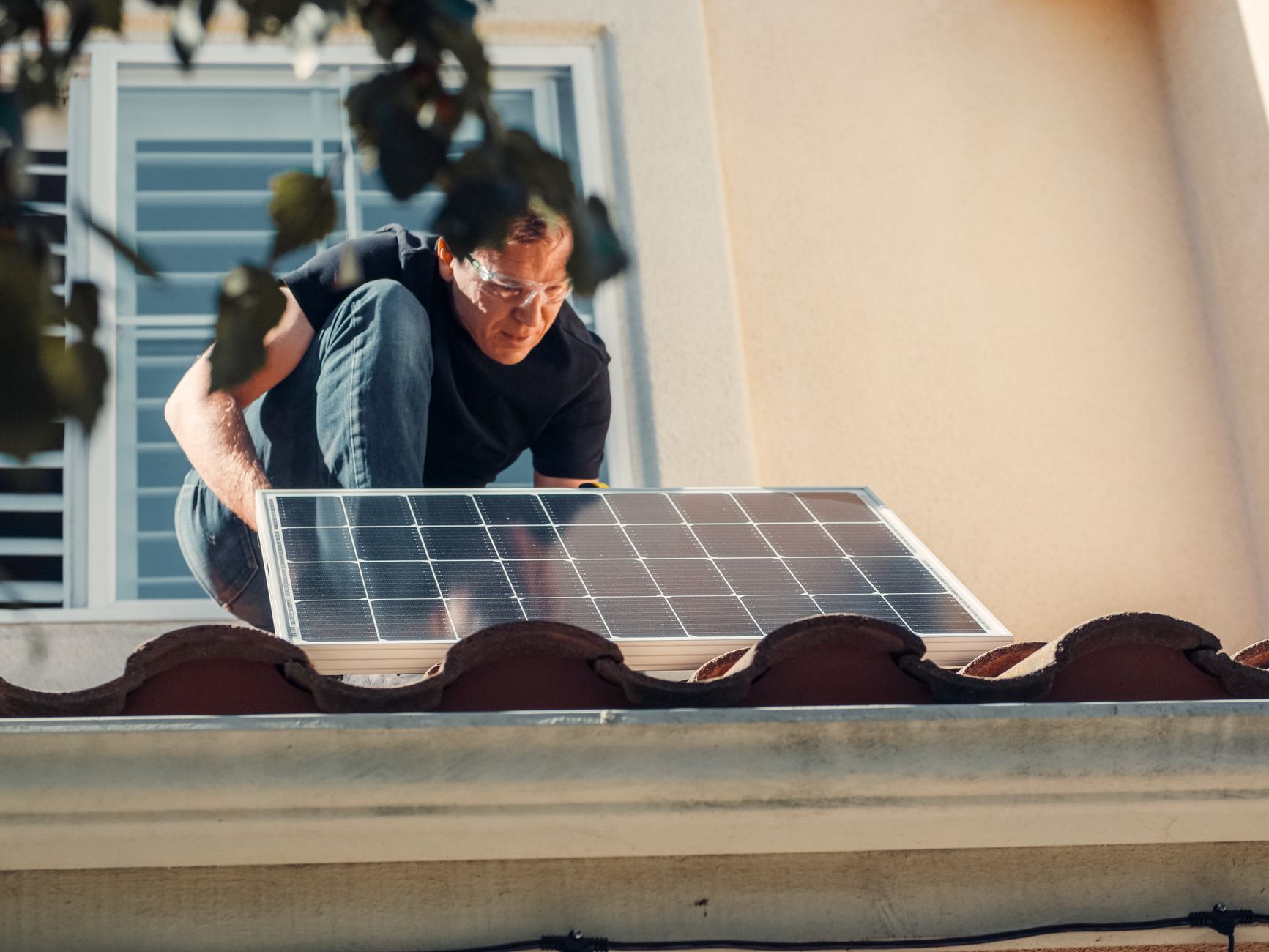 Roofer inspecting a cool roof system on a home in Boulder City, Nevada, with the desert mountains in the background.